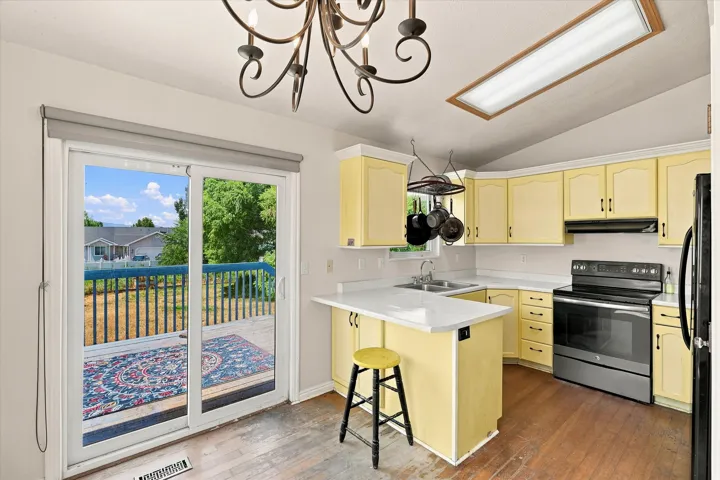 Kitchen with light-toned cabinetry, light countertops, and a full suite of black and stainless steel appliances