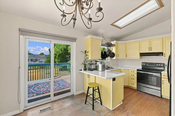 Kitchen featuring light yellow cabinetry, white countertops, and wood-finish flooring
