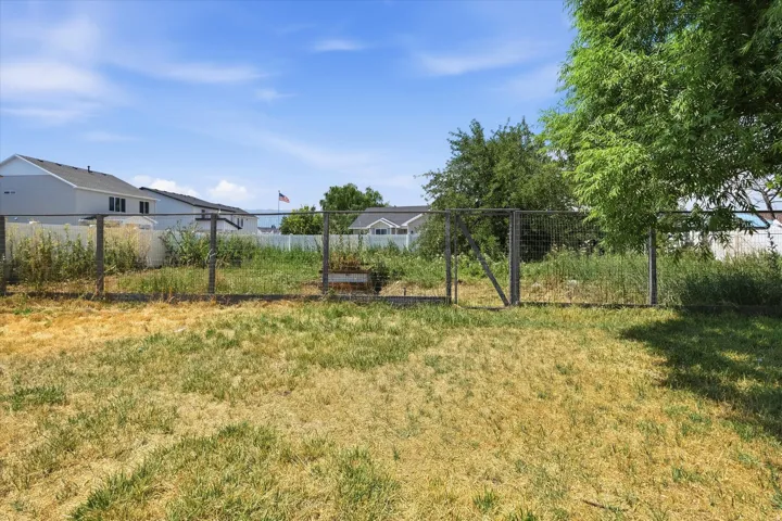 Expansive outdoor space featuring a large lawn area and a chain-link fence