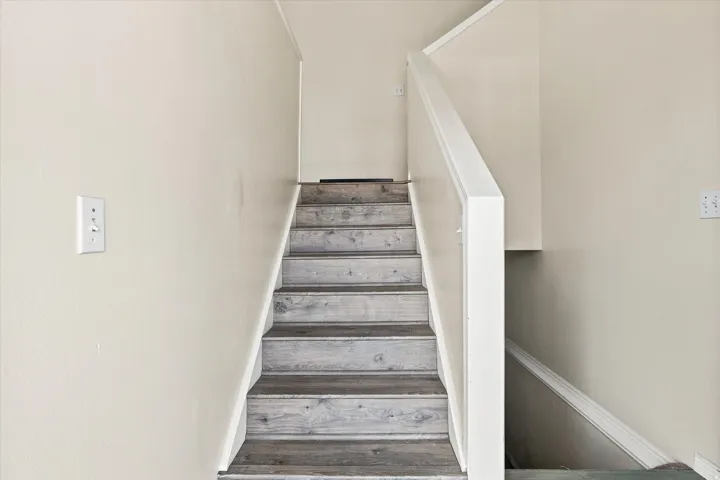Staircase featuring wood-finish treads and white risers