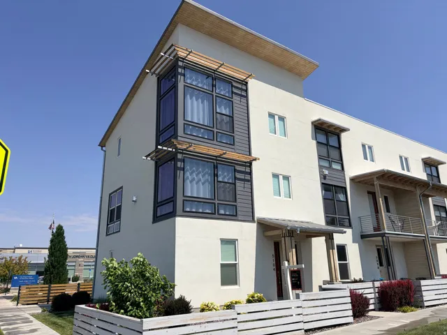 Modern multi-story exterior with stucco finish and wood-look architectural accents
