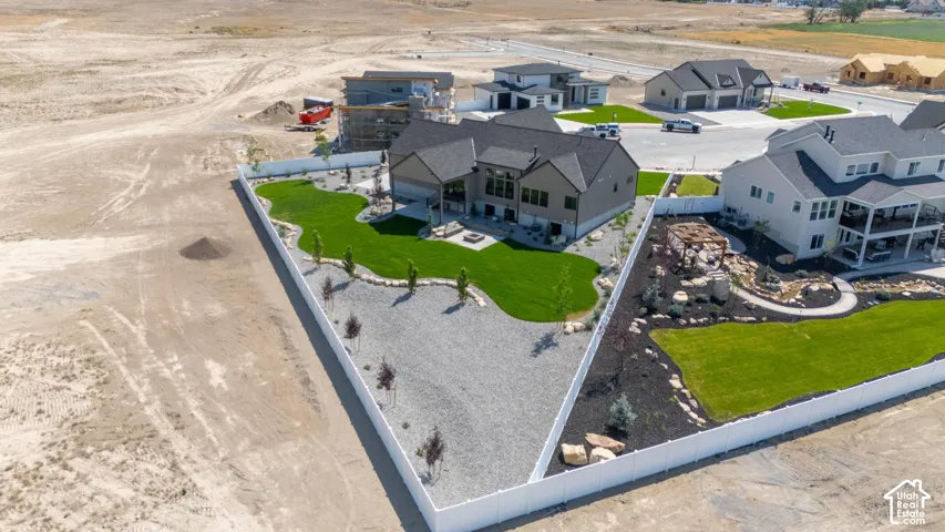 Expansive property featuring a meticulously maintained lawn, white perimeter fencing, and mature landscaping
