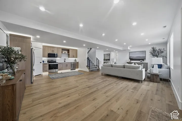 Spacious open-concept living area featuring light wood-finish flooring throughout