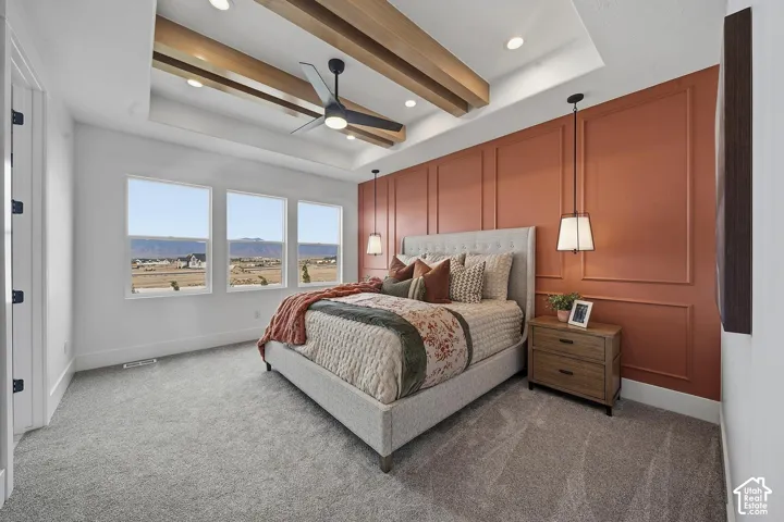 Bedroom featuring a tray ceiling with wood-finish beams, a ceiling fan, recessed lighting, and a paneled accent wall