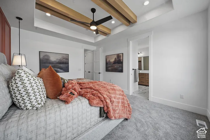 Tray ceiling with exposed wood-finish beams, recessed lighting, and a ceiling fan