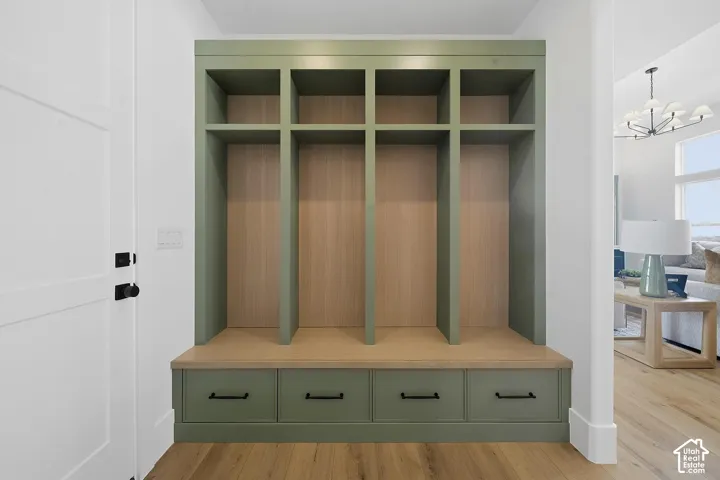 Built-in storage bench featuring a sage green finish, four lower drawers with black hardware, and four upper cubbies