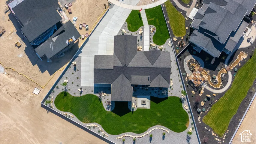 Newly constructed residence featuring a multi-gabled roofline, concrete driveway, and a manicured lawn