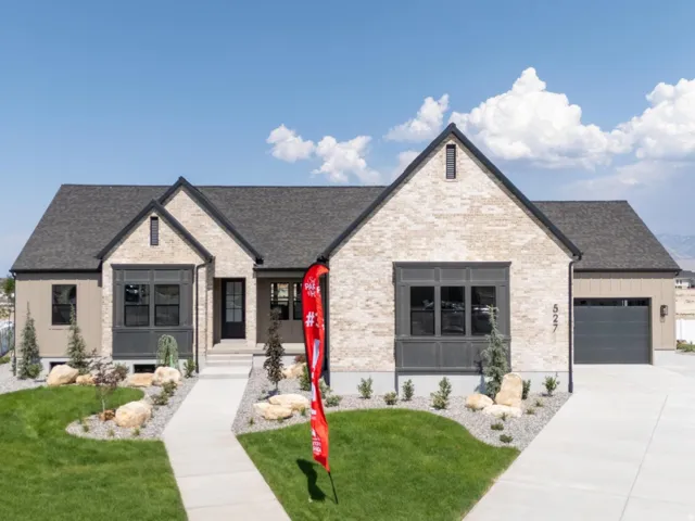 Modern residential home featuring a striking stone and stucco exterior with peaked rooflines and architectural detailing