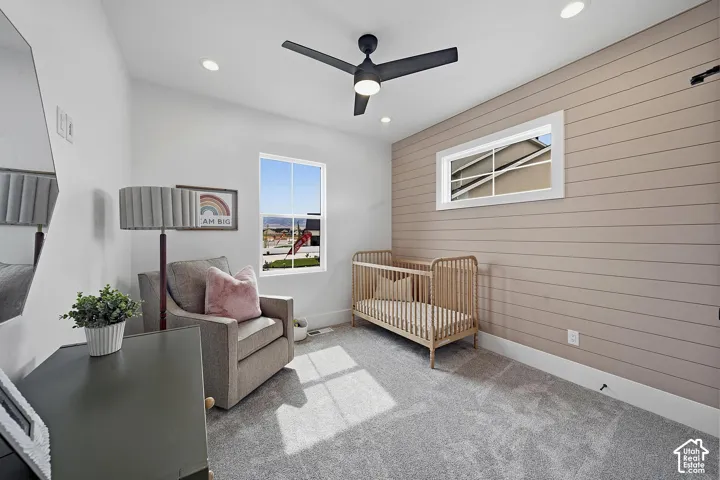 Interior room featuring a shiplap accent wall, carpet flooring, a ceiling fan, and recessed lighting