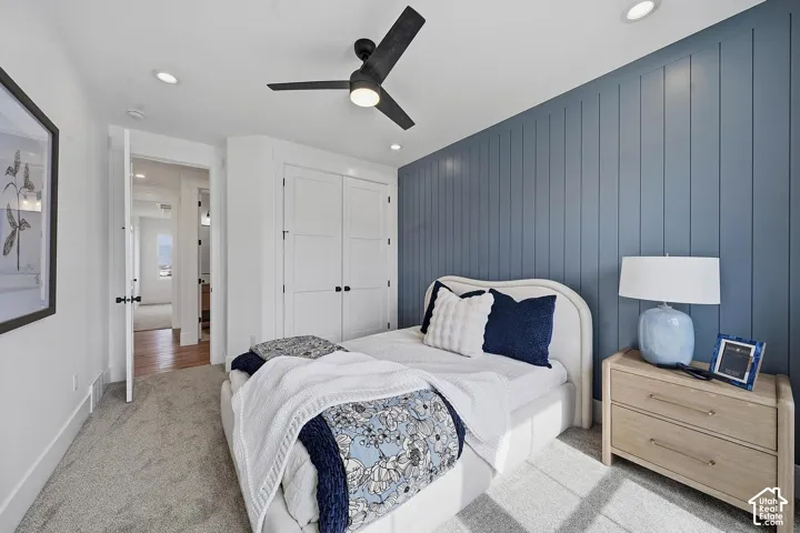 Bedroom featuring a shiplap accent wall in soft blue-gray, recessed ceiling lighting, and a modern ceiling fan with integrated light fixture