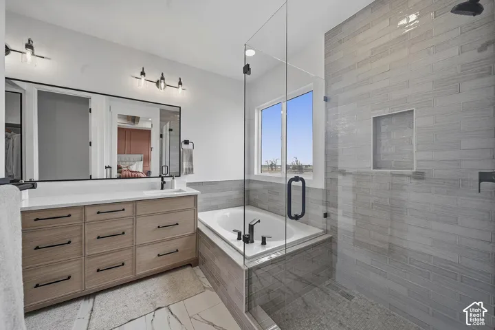 Contemporary bathroom featuring a spacious glass-enclosed shower, a separate soaking tub, and a double vanity with a light wood-finish cabinet