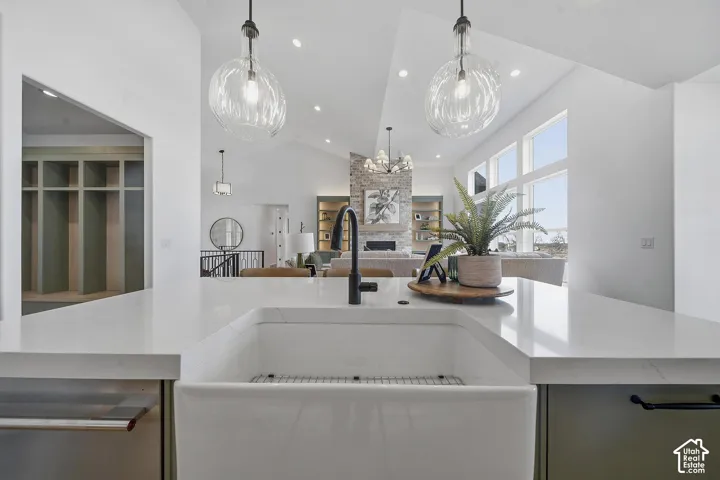 Kitchen island featuring a white apron-front sink, a matte black faucet, and white countertops