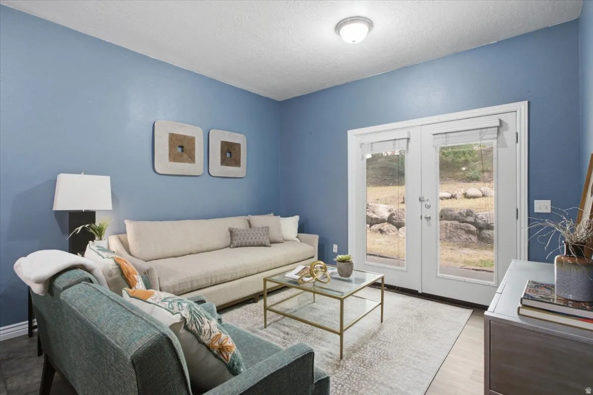 Inviting living space featuring a light blue wall finish, white ceiling, and wood-finish flooring