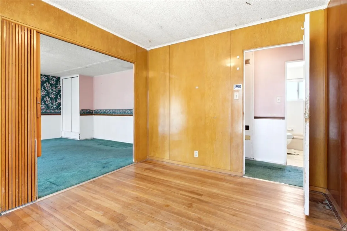 Hardwood flooring in the foreground with paneling walls