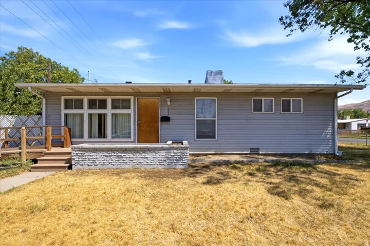 Single-story residence featuring light gray siding and a flat roofline