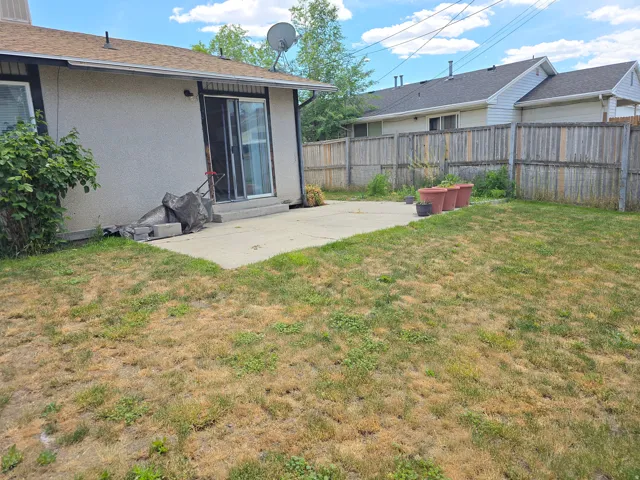 Rear exterior with a concrete patio and a sliding glass door