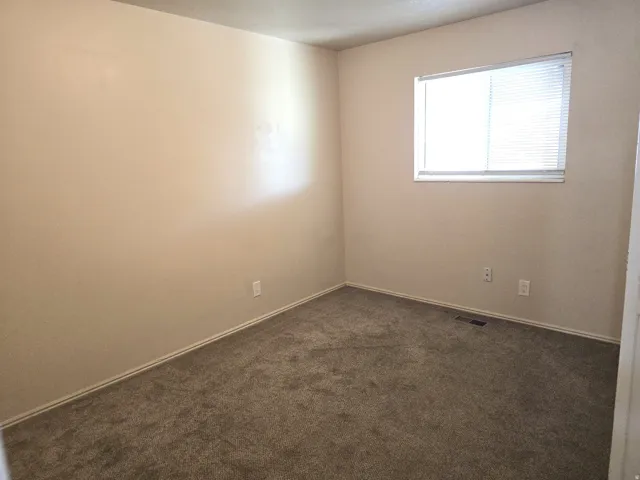 Neutral-toned walls complement the gray carpeting