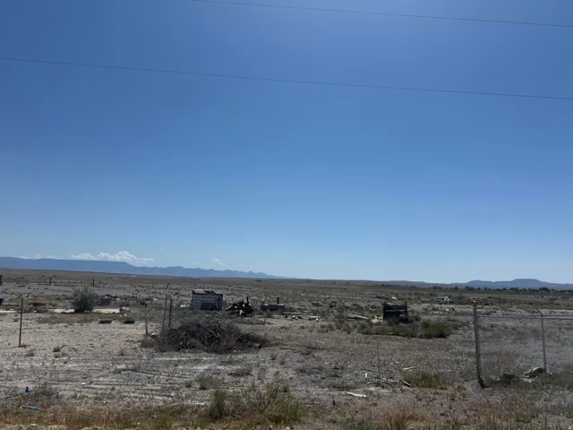 Expansive open land with distant mountain ranges under a clear sky