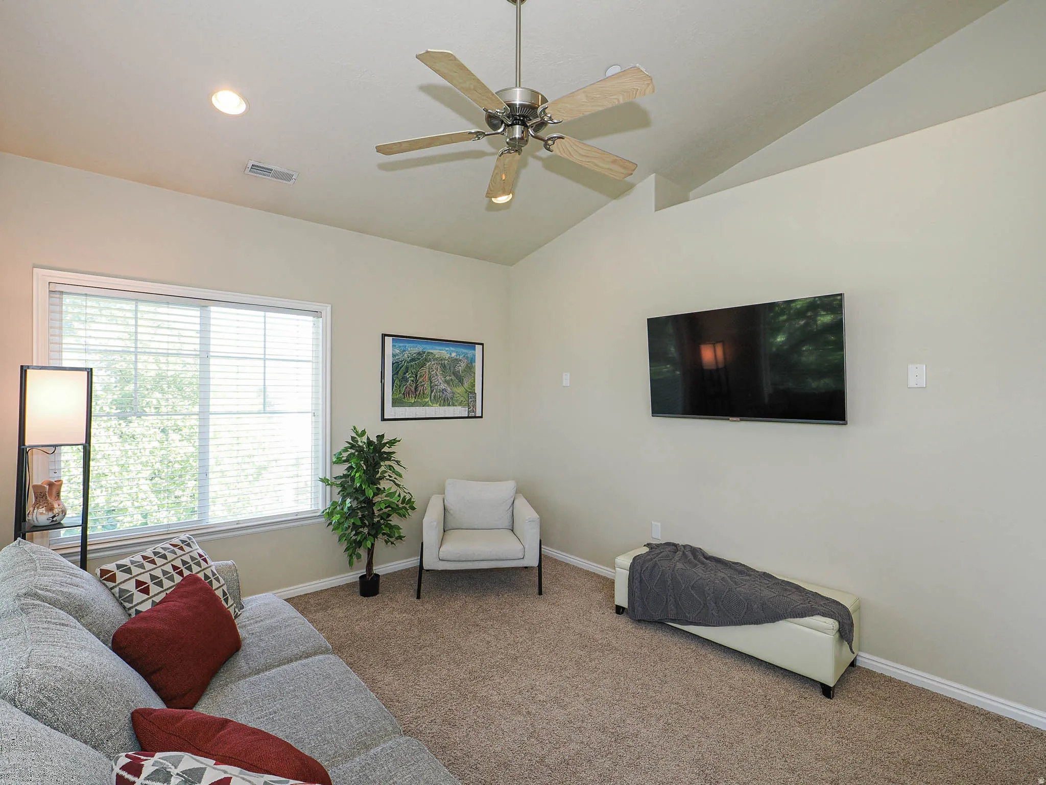Living area featuring vaulted ceilings with a ceiling fan, recessed lighting, and a large window with horizontal blinds