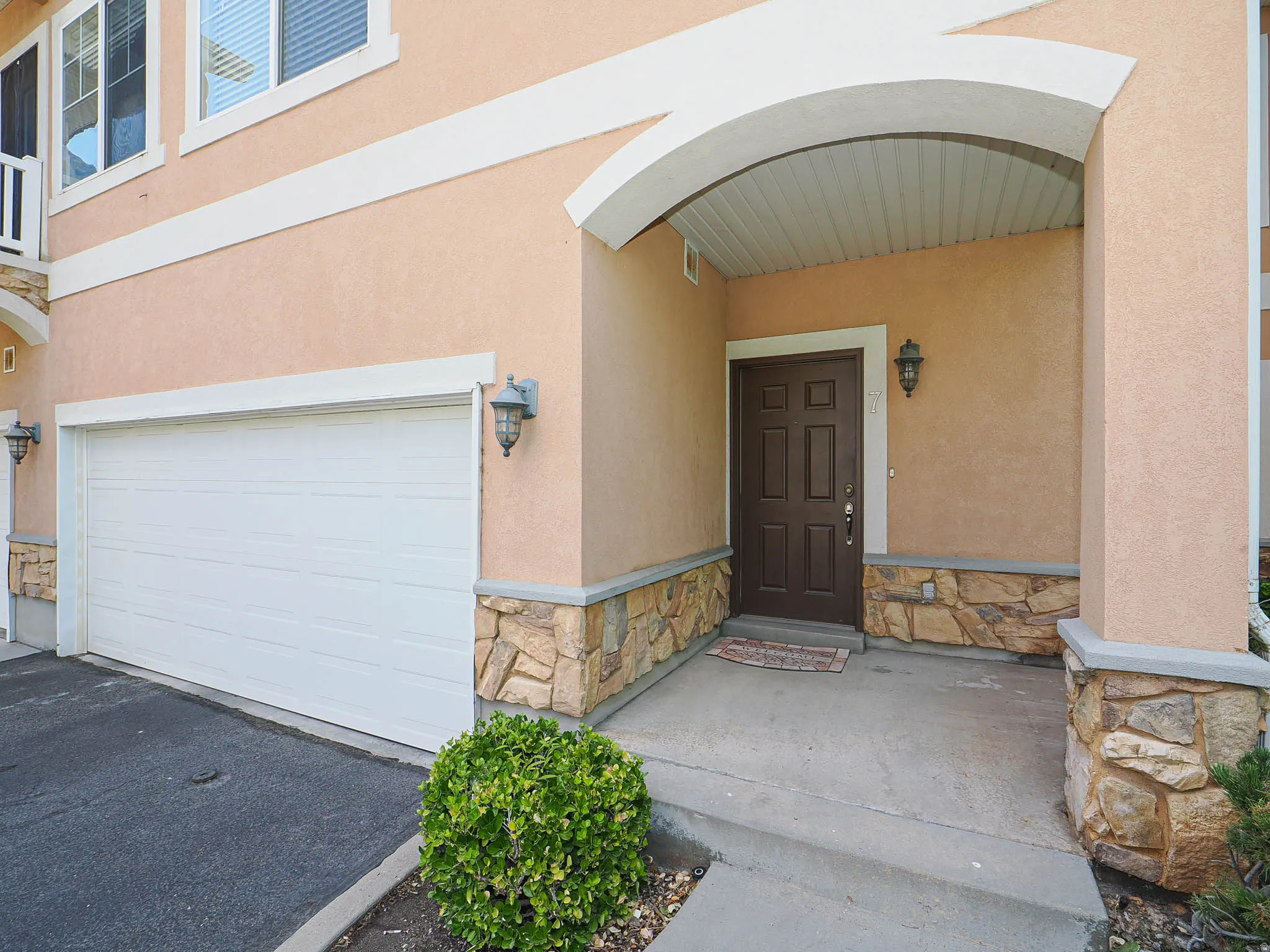Stucco exterior with stone accents and an arched entryway