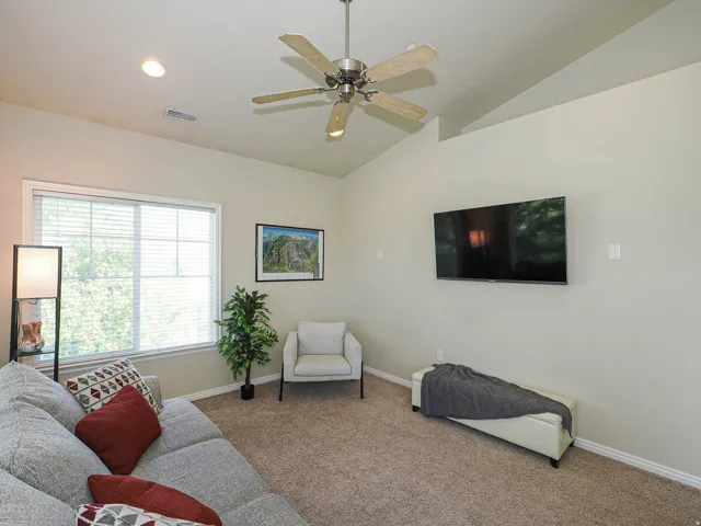 Living area featuring vaulted ceilings with a ceiling fan, recessed lighting, and a large window with horizontal blinds