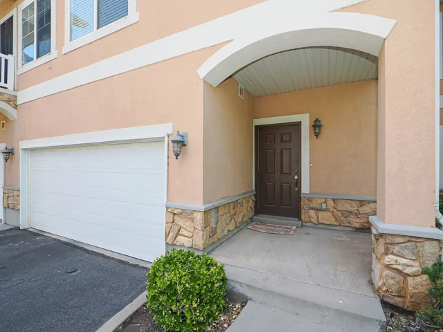 Stucco exterior with stone accents and an arched entryway