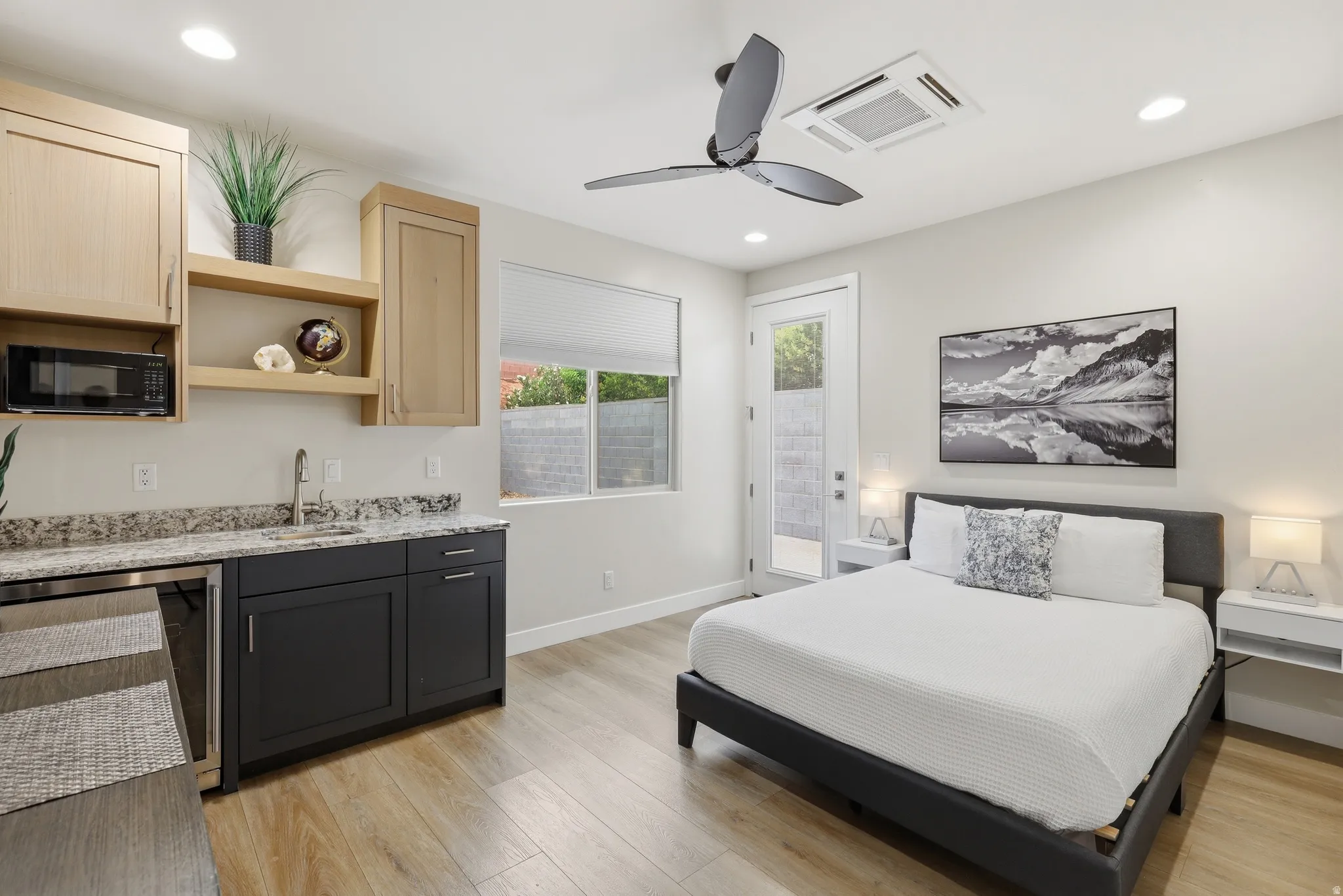 Modern studio space featuring wood-finish flooring, a contemporary ceiling fan, and recessed lighting