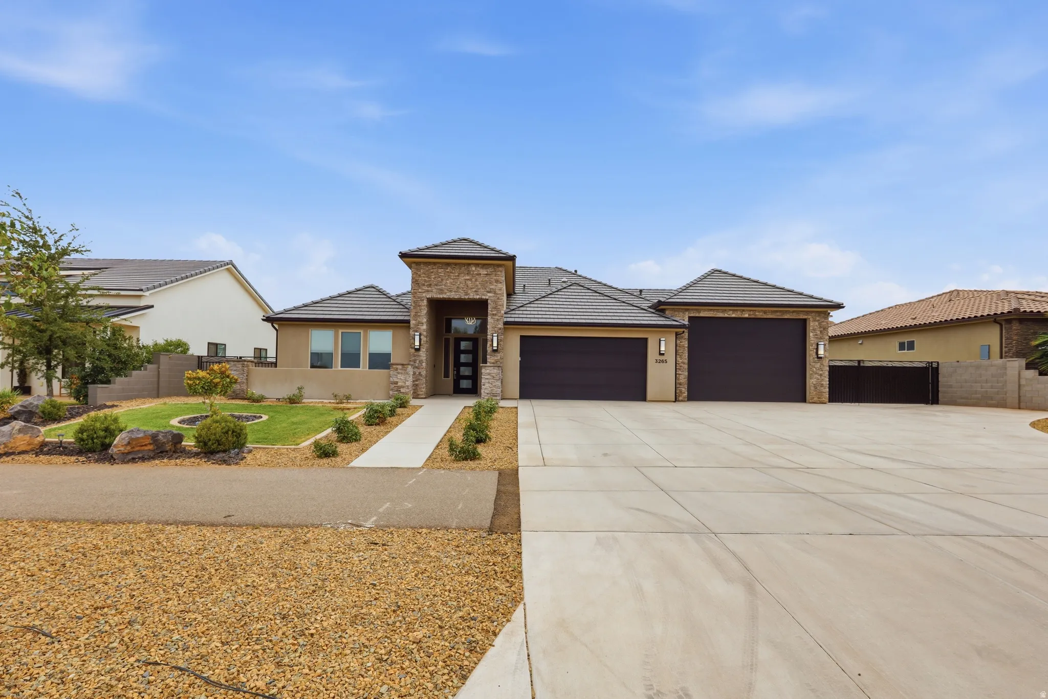 Contemporary stucco and stone-clad exterior with a tiled roof