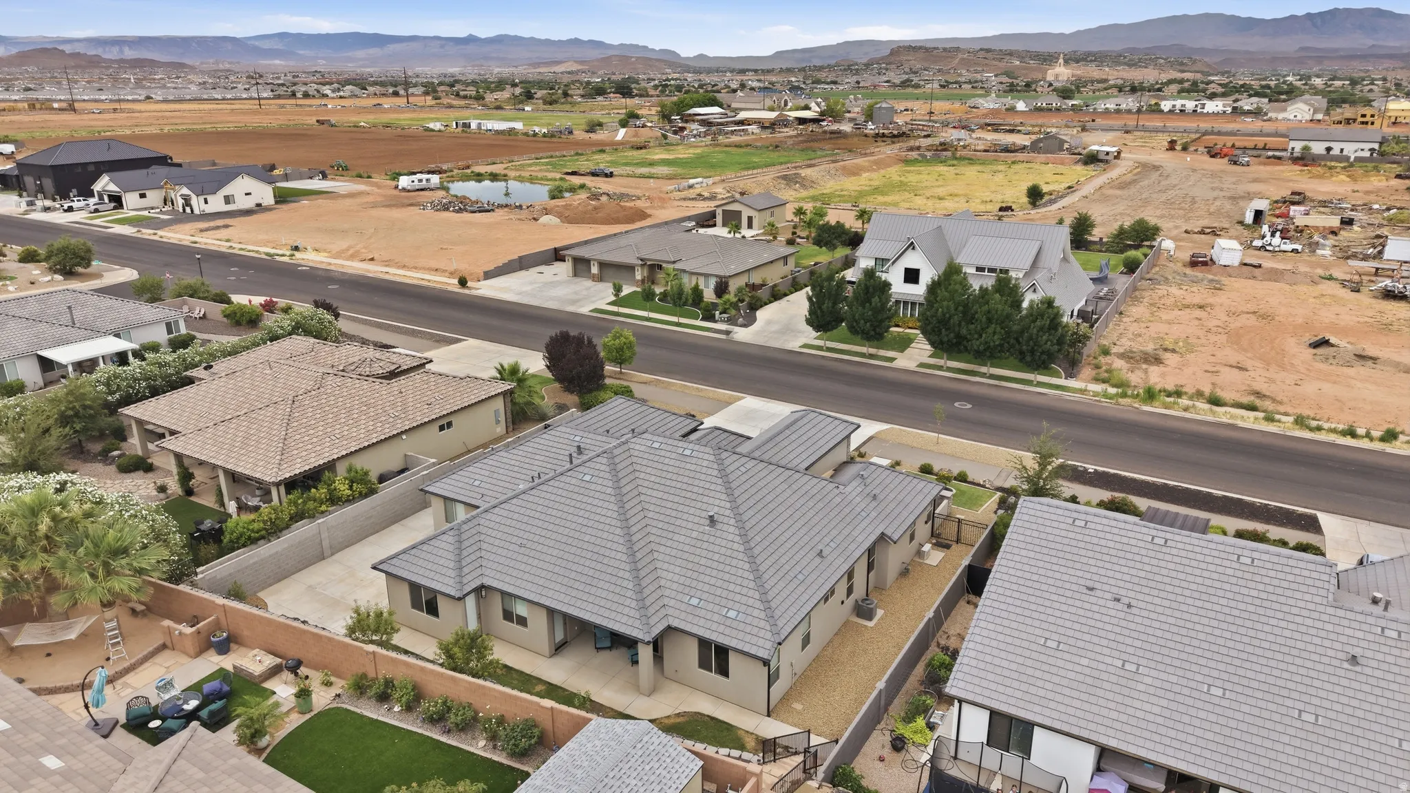 Contemporary residential property featuring a gray tile roof and a fenced perimeter