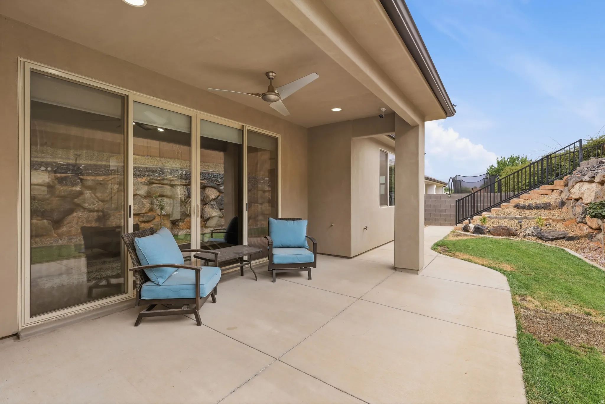 Paved patio with an overhead ceiling fan, recessed lighting, and large sliding glass doors