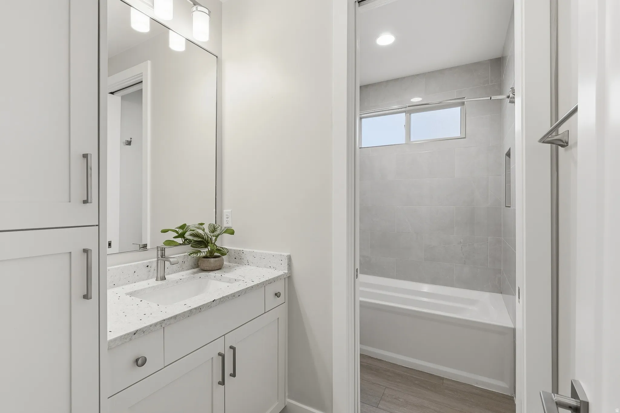 Bathroom featuring a vanity with a white countertop and integrated sink, brushed nickel faucet, and a large mirror