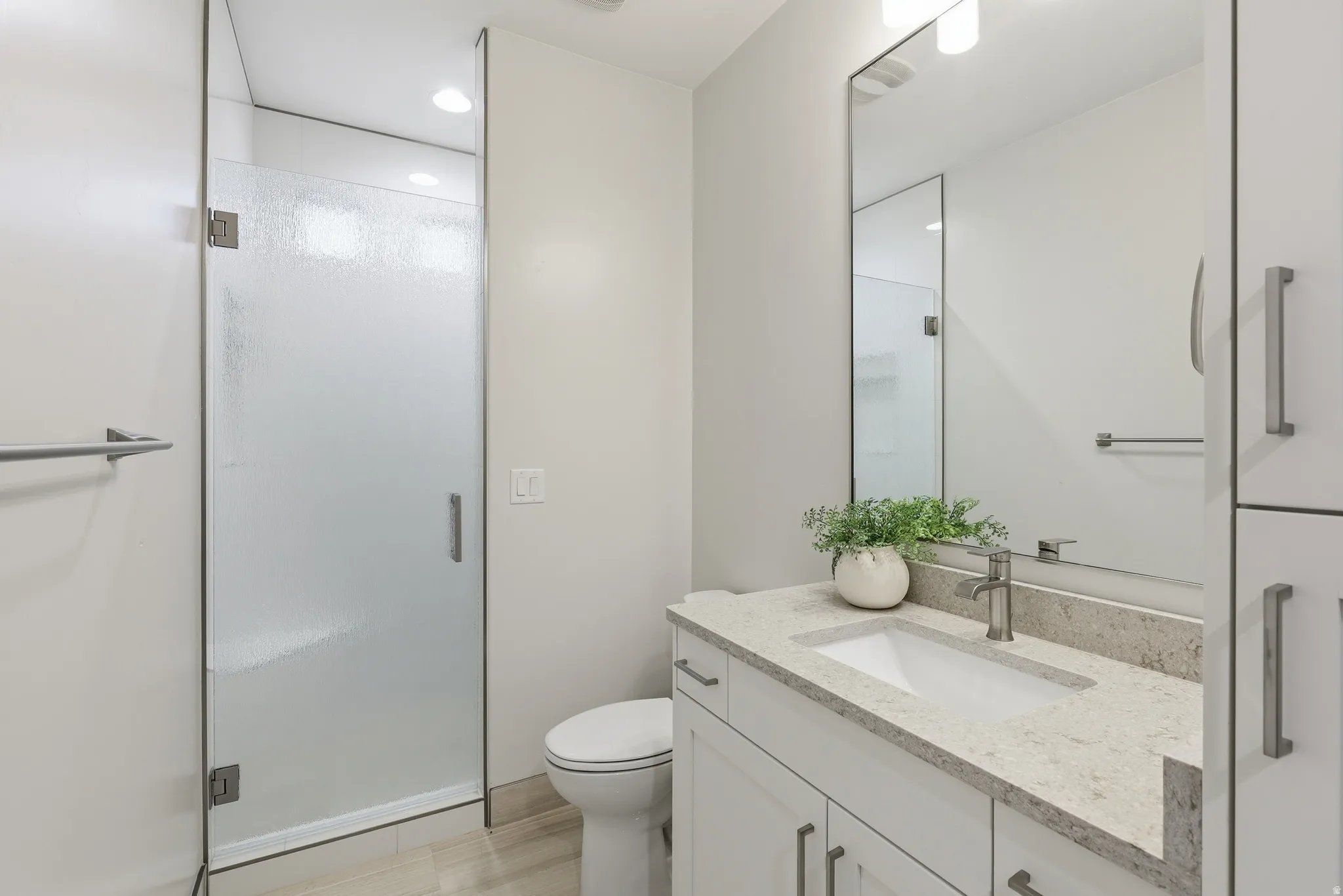 Sleek bathroom featuring a frosted glass shower enclosure