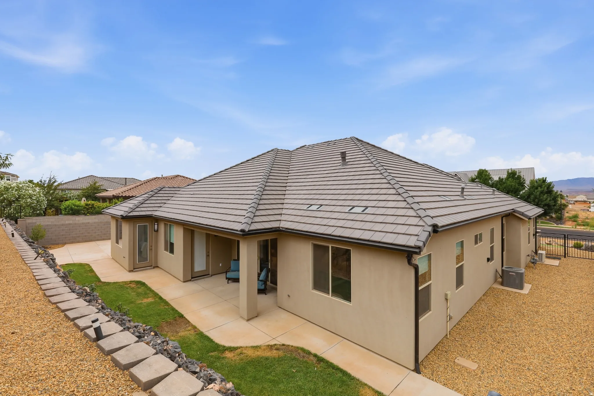 Rear exterior featuring a covered patio, stucco siding, and a tiled roof