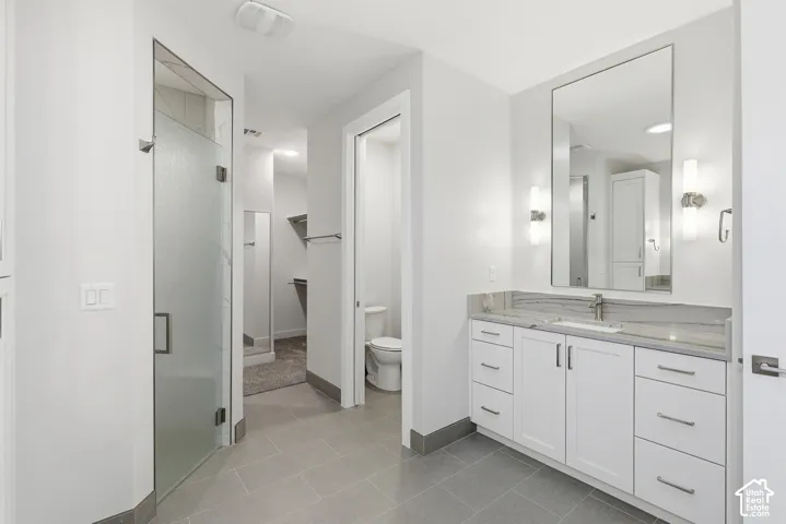 Contemporary bathroom featuring a single vanity with stone countertop, undermount sink, and brushed nickel hardware