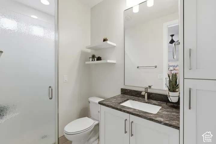 Bathroom vanity featuring a dark granite countertop, undermount sink, and brushed nickel faucet