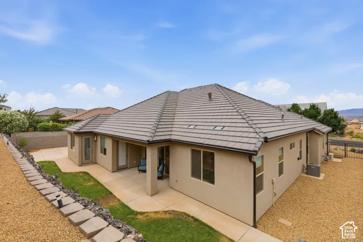 Rear exterior featuring a covered patio, stucco siding, and a tiled roof