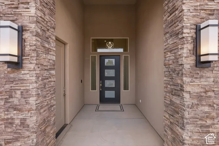 Stone veneer columns framing a recessed entry with sconce lighting