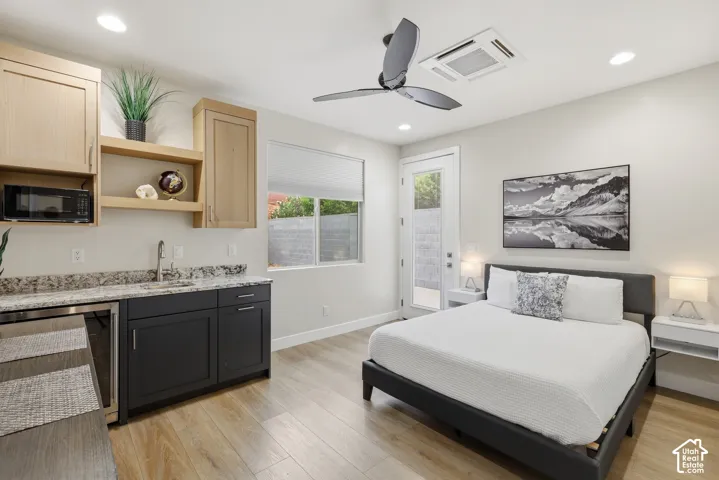 Modern studio space featuring wood-finish flooring, a contemporary ceiling fan, and recessed lighting