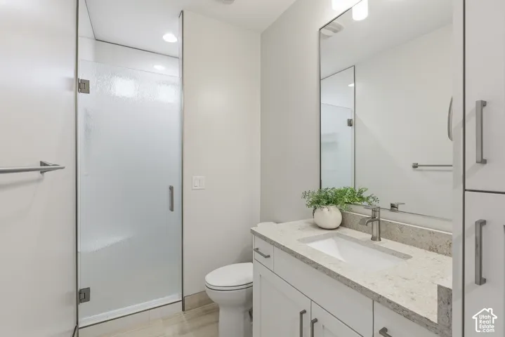 Sleek bathroom featuring a frosted glass shower enclosure