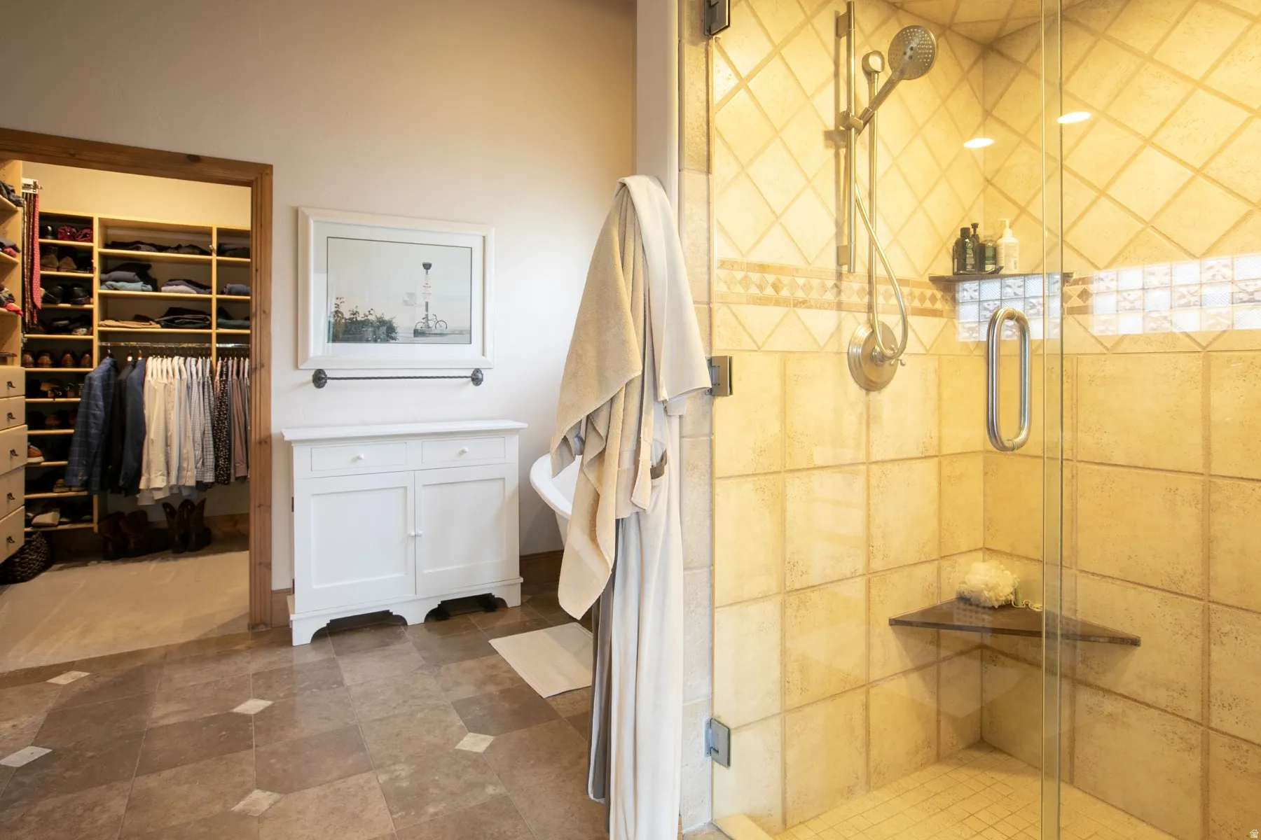 Walk-in tiled shower with glass enclosure, built-in shelving, and a corner seat
