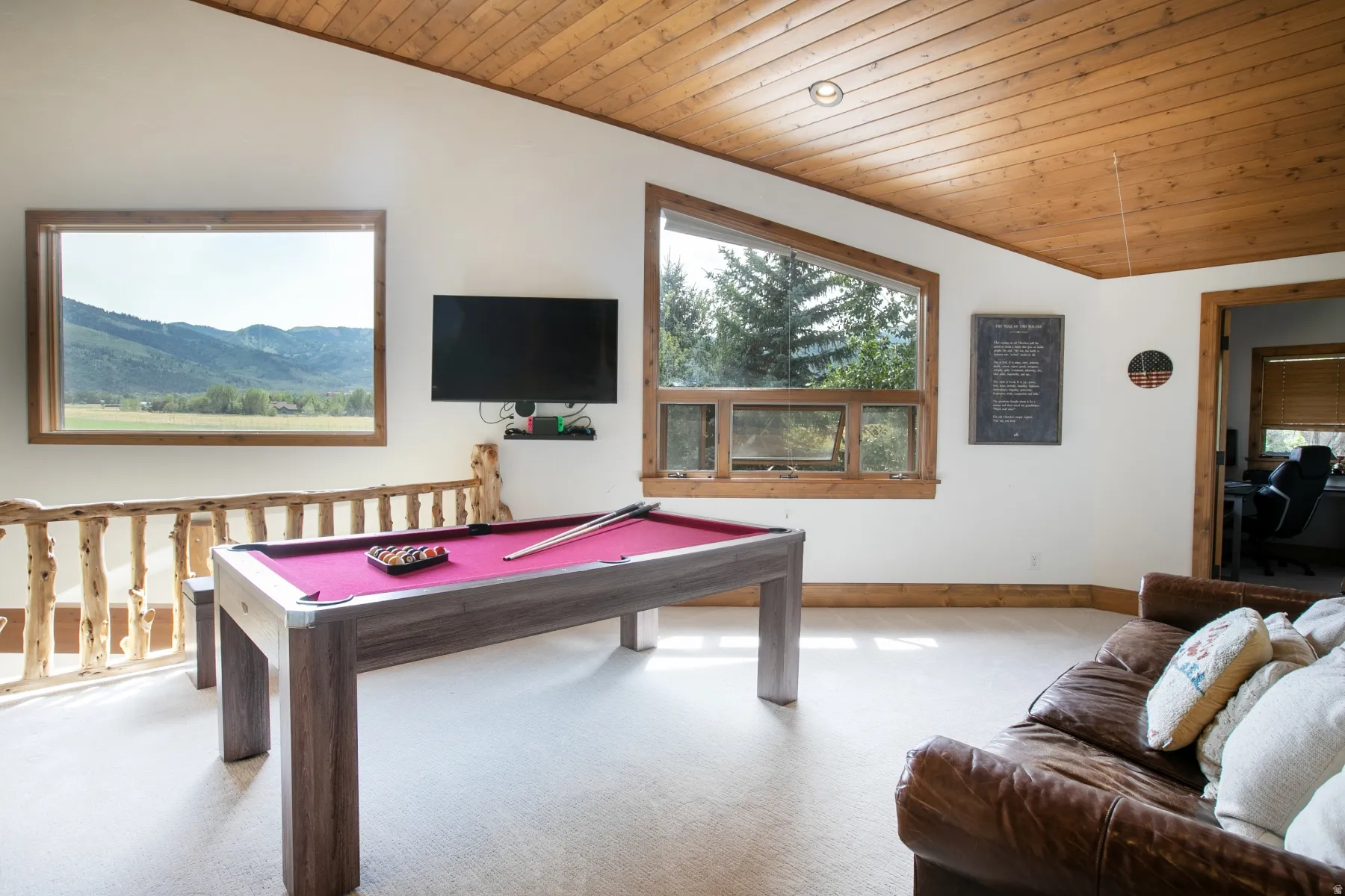 Loft area featuring a wood plank ceiling, light-colored carpeting, and natural wood trim around windows and doorways