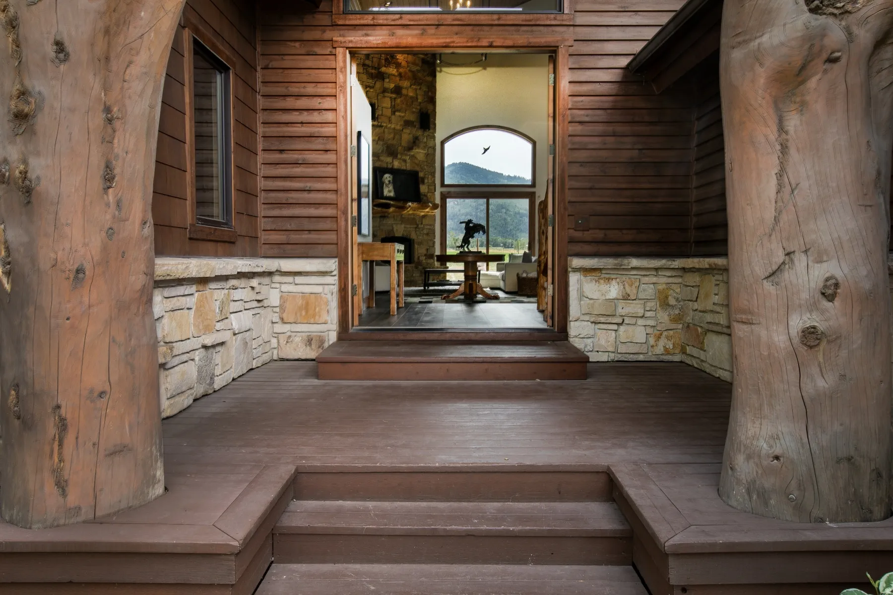 Front entrance featuring natural log columns and horizontal wood siding