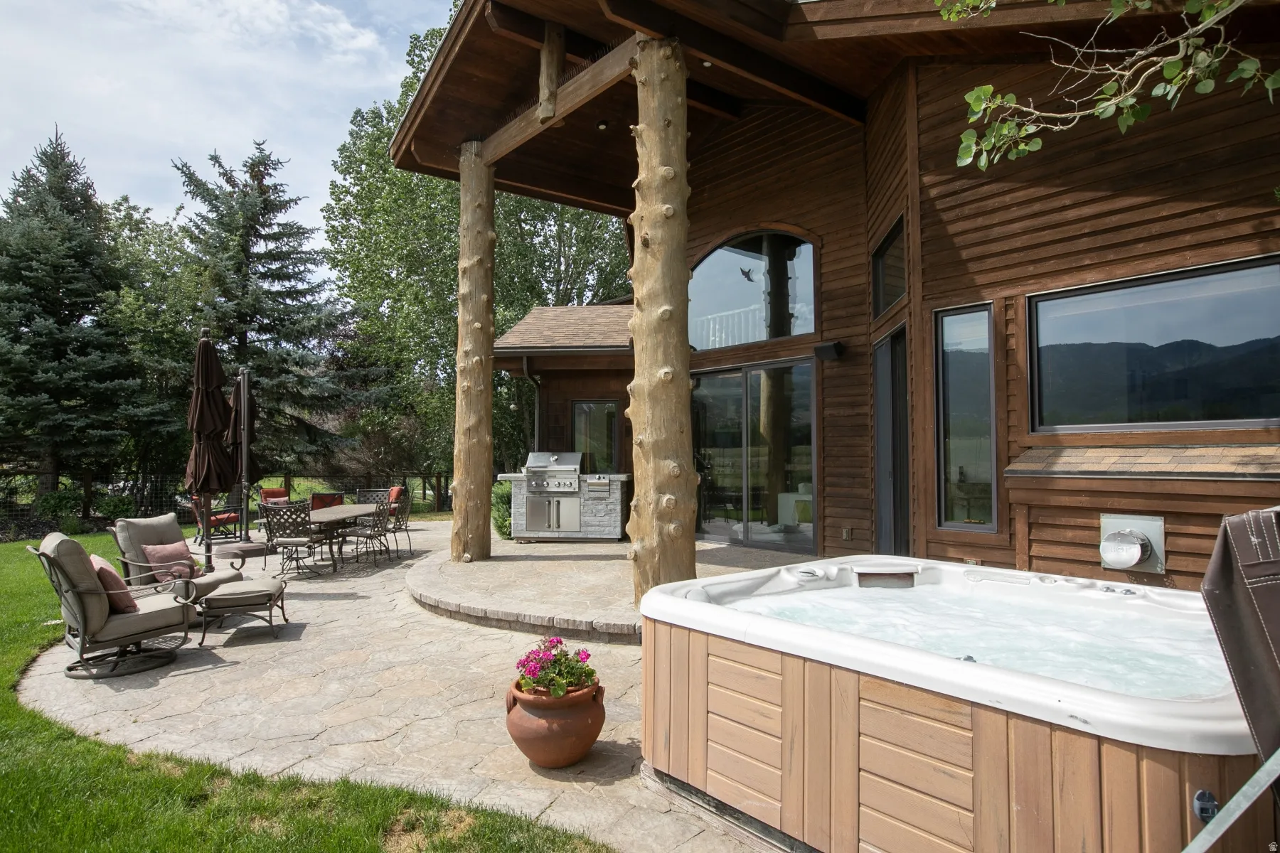 Outdoor patio featuring a hot tub, built-in outdoor grill station, and a stamped concrete surface