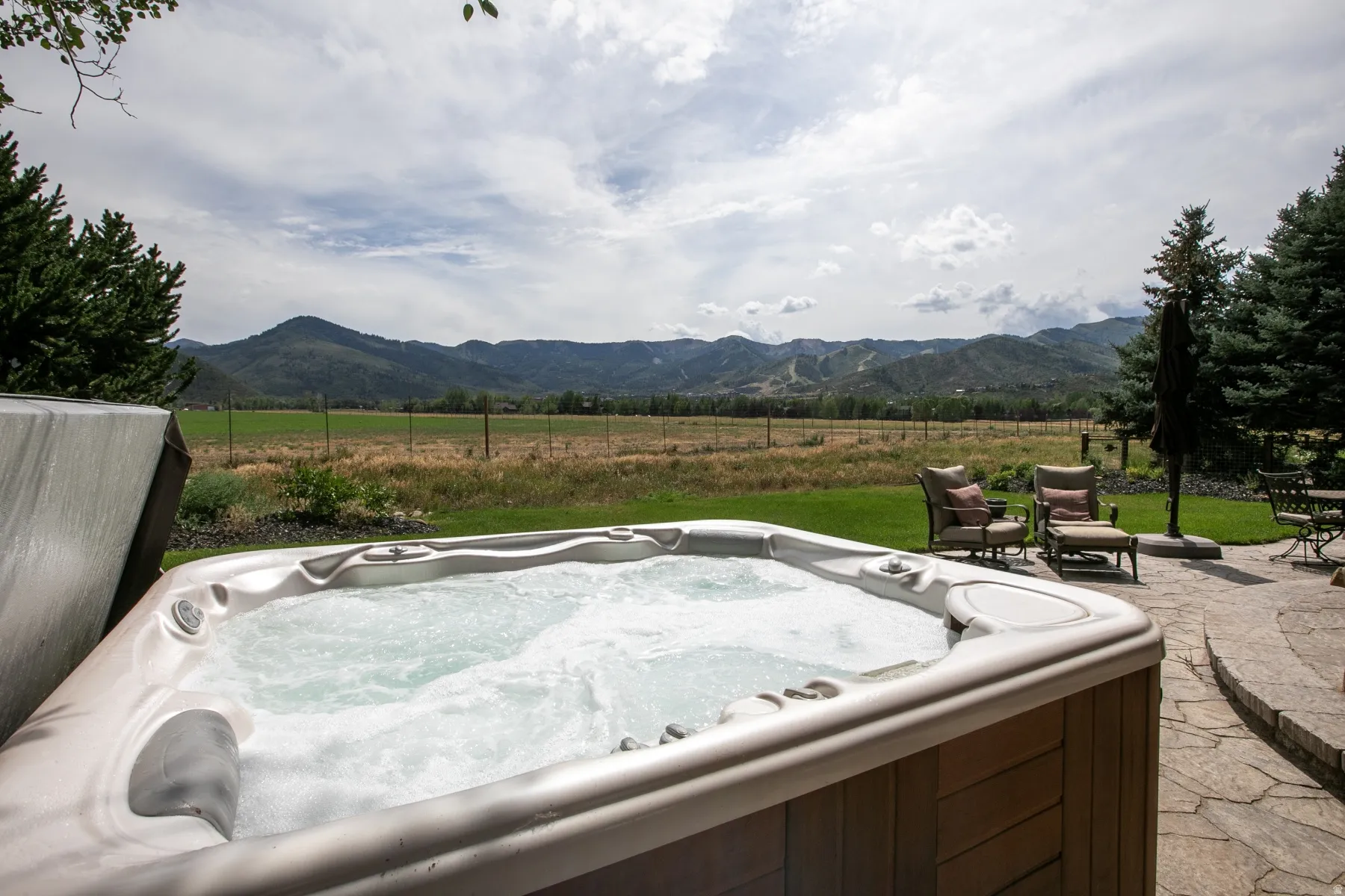 Outdoor hot tub with wood-finish exterior paneling and bubbling water