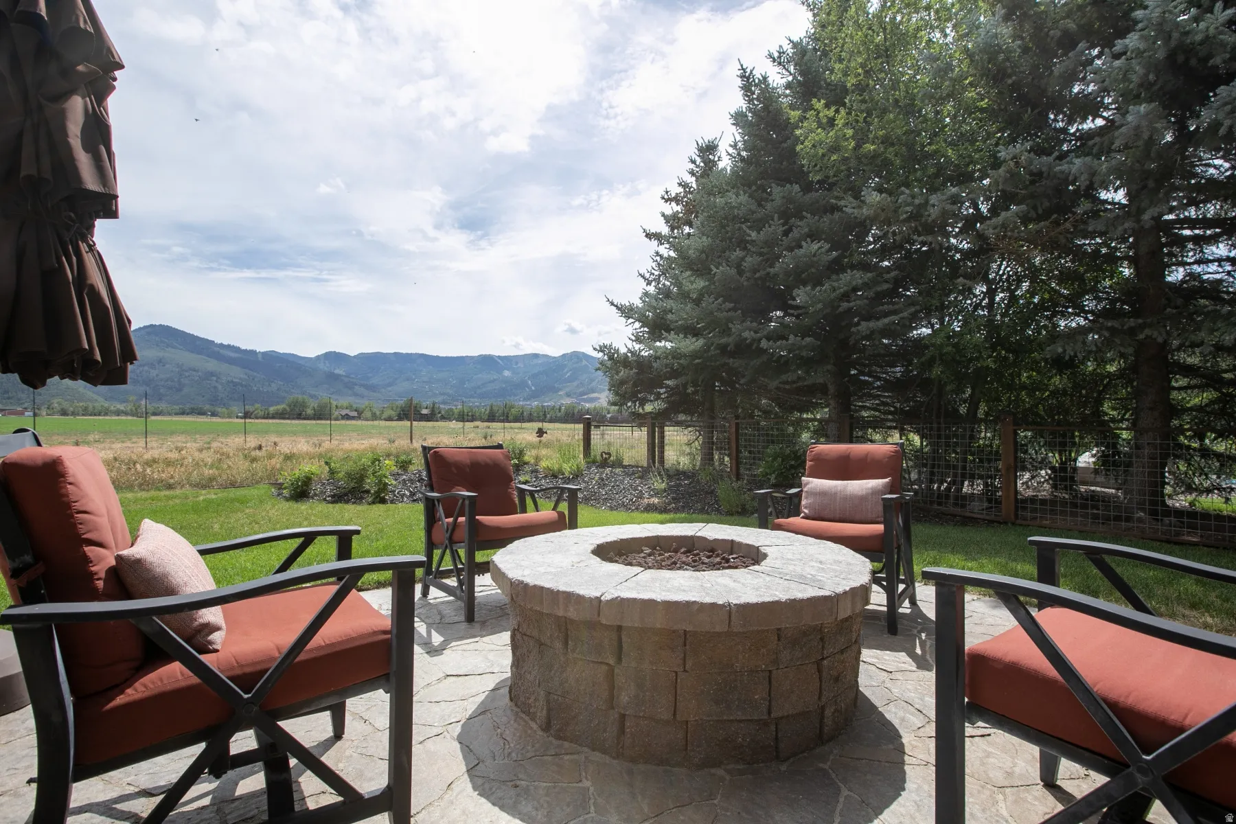 Stone-block fire pit centered on a flagstone patio