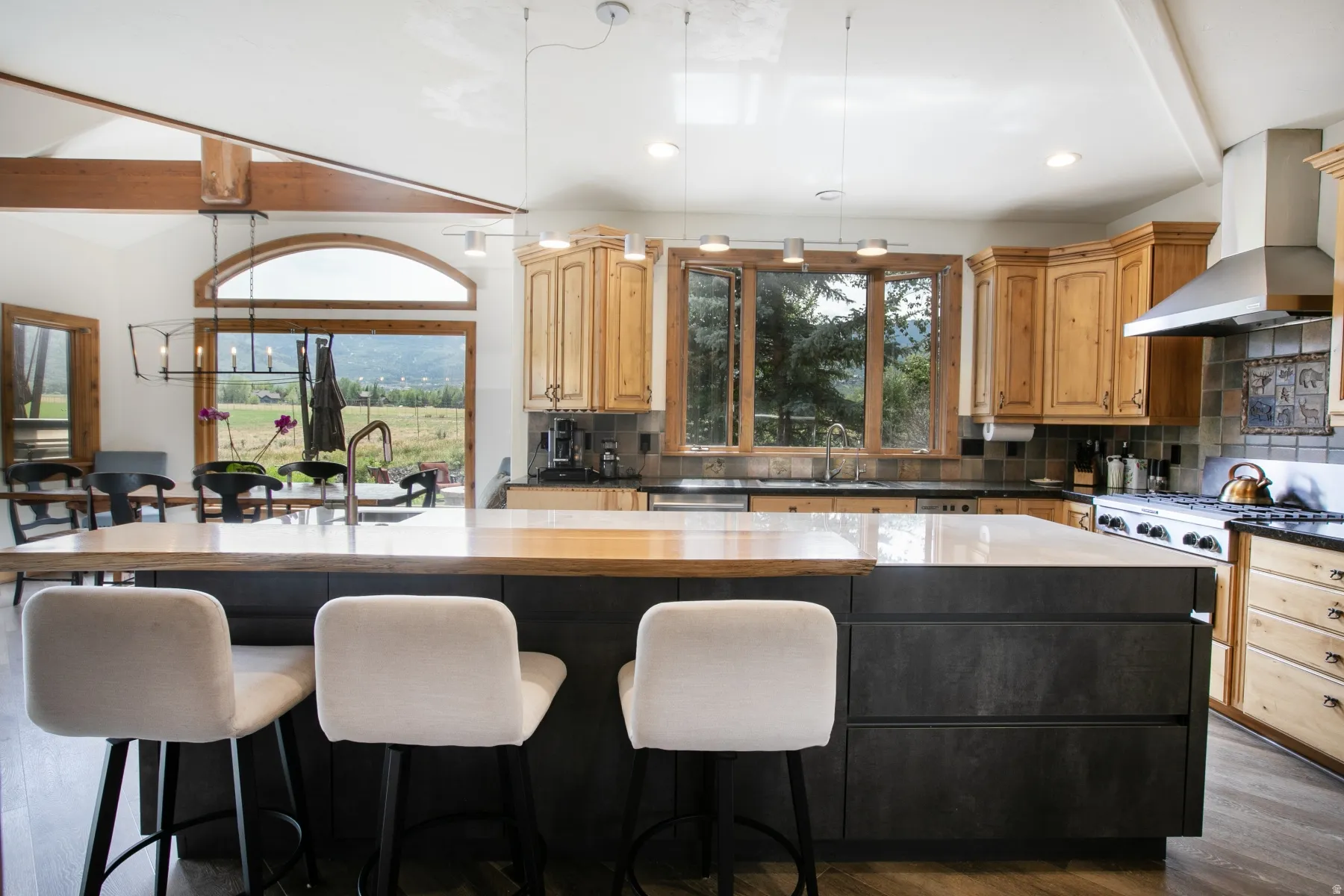 Open-concept kitchen with a large central island featuring a light-toned countertop and a darker base with integrated storage
