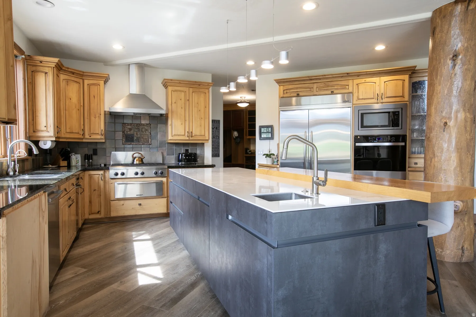 Contemporary kitchen featuring a large island with an integrated sink and breakfast bar