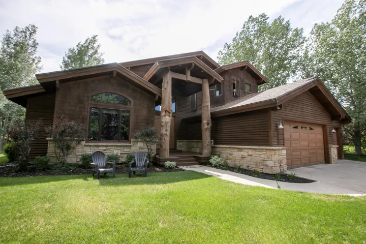 Rustic-style residence featuring natural wood siding and a stone foundation