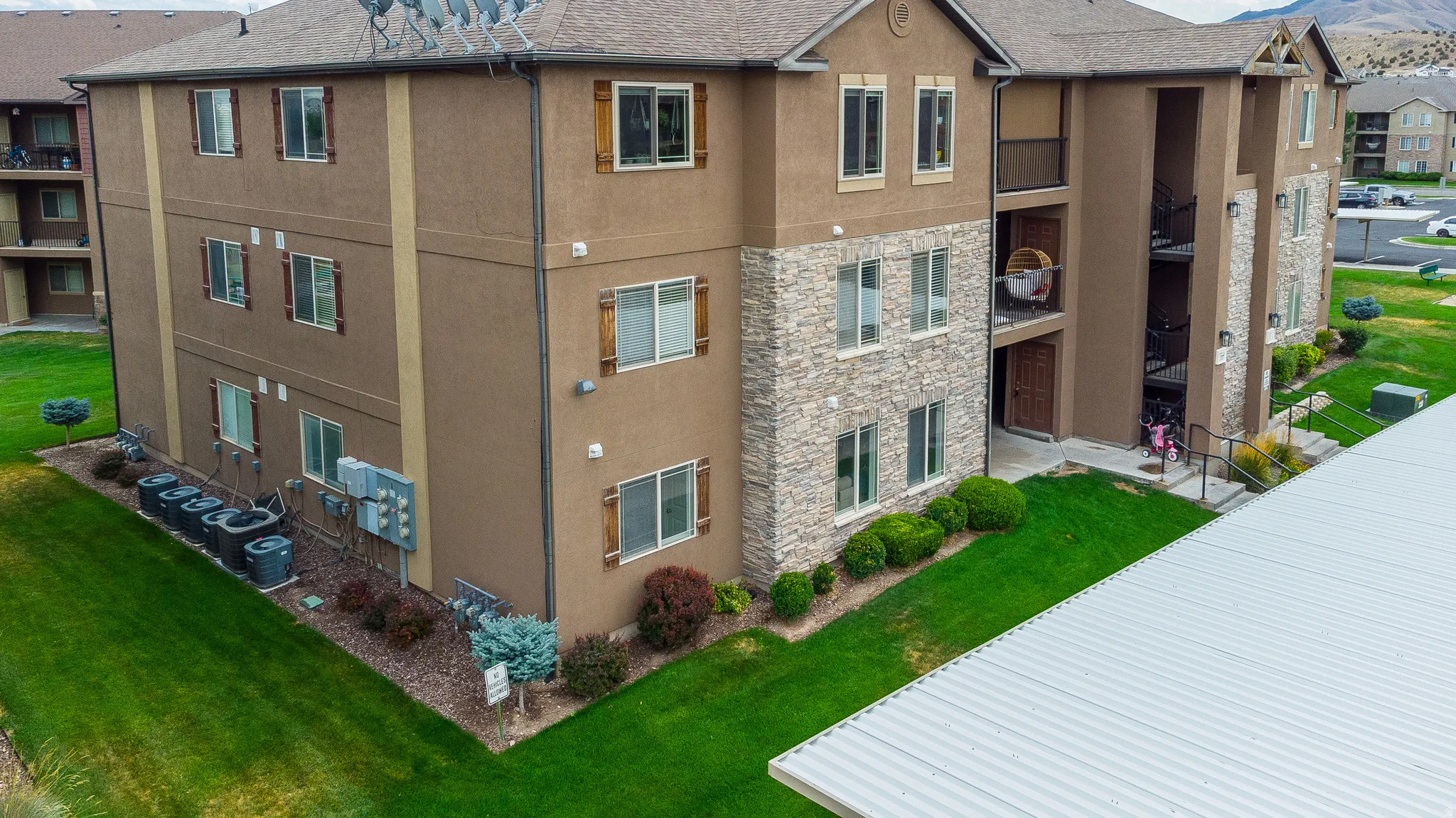 Multi-story building featuring a stucco and stacked stone facade with decorative shutters