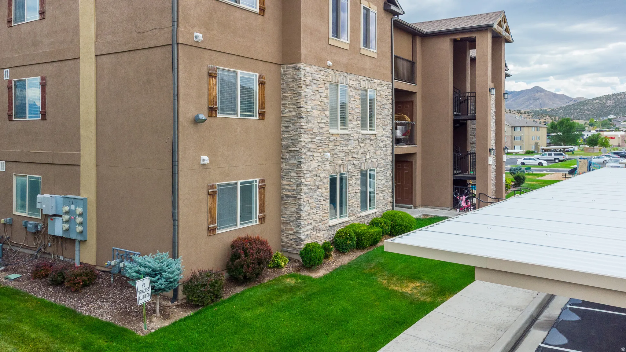 Multi-story building with textured stucco siding and stone veneer accents